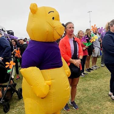 Woman posing with a Halloween Winnie-the-Pooh costumed attendee at the Alzheimer's Walk