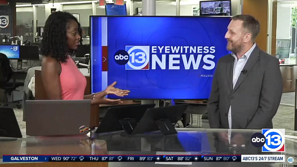 Mr. Courtney Hochhalter of West Houston and Sugar Land Right at Home looks across a TV news set to the African American Eyewitness News host