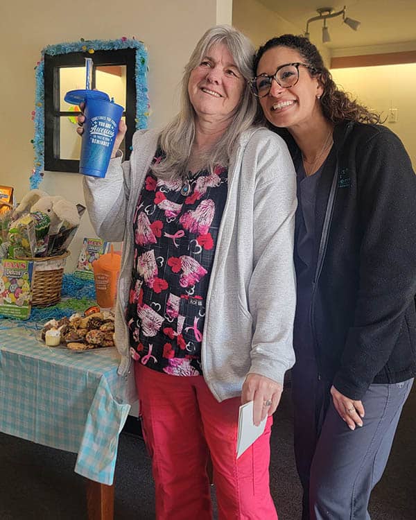 Two caregivers with a cupful of Easter candy.