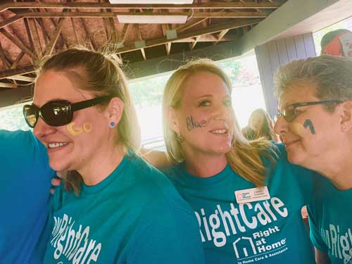 Three women at picnic wearing Right at Home shirts