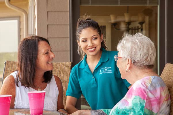 Three females sitting on patio having drinks