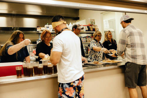 Volunteers at Camp Hope behind a food counter serving food to veterans