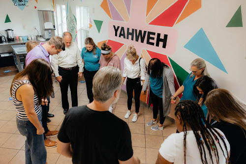 Mission of Yahweh faith-based shelter team of men and women coming together in a prayer circle