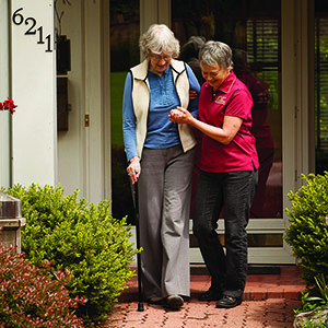 Caregiver Helping A Client Go For A Walk