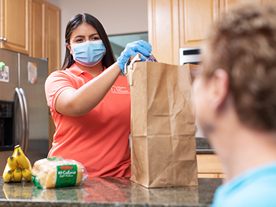 Caregiver Unpacking Groceries With Client