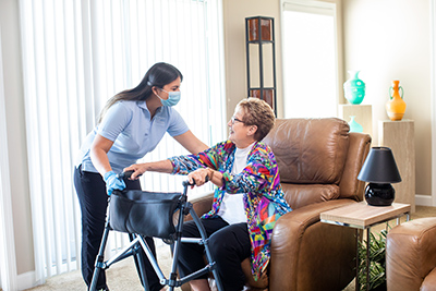 Caregiver Helping Client With A Walker