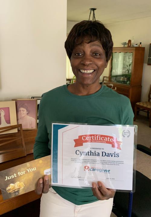 Cynthia Davis holding her Caregiver of the Month certificate 