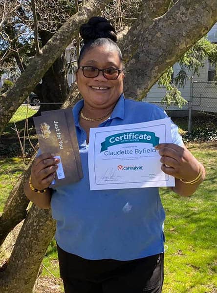 Claudette Byfield holding her Caregiver of the Month Award certificate for March of 2021