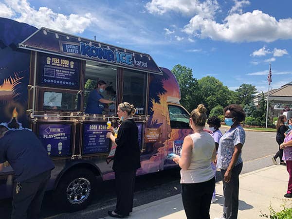 Staff members at Carillon Rehab waiting at the Kona Ice truck