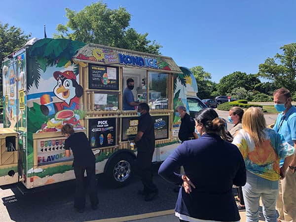 Staff members of Huntington Hills Rehab Center waiting in line at the Kona Ice truck