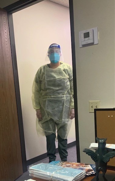 Caregiver dressed in medical gown and PPE