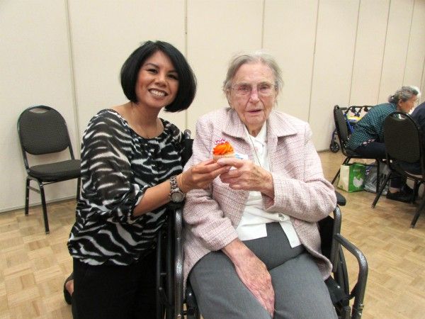 Grace Atwood with Senior with a Birthday cupcake at the Cypress Senior Center