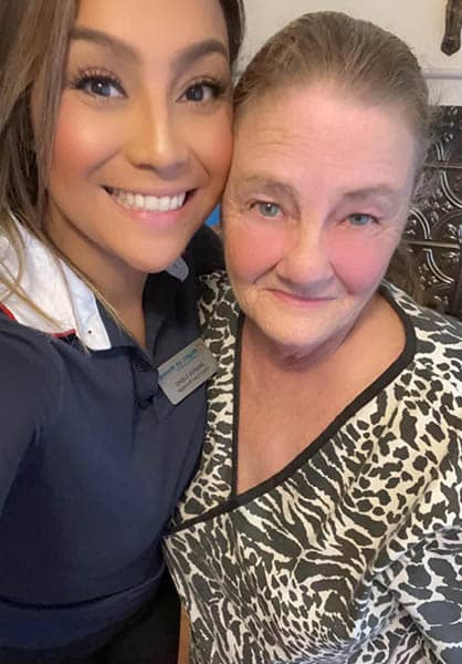 A female office staff member for Right at Home Brenham, TX, and a female caregiver standing next to each other.