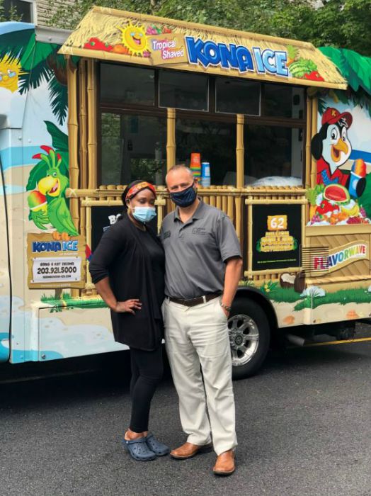 Right at Home Westchester, NY owner Lou Giampa along with one other person wearing face masks in front of a Kona Ice Truck at Sprain Brook Manor Rehabilitation in Scarsdale, NY