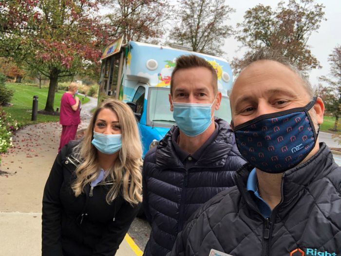 Right at Home Westchester, NY owner Lou Giampa along with a man and a woman posing in front of the kona ice truck at Grove Rehab in Valhalla, NY