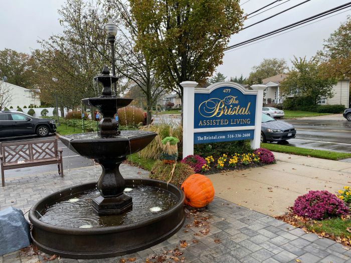 Right at Home South Shore Long Island delivering refreshments to front line workers at the Bristal North Woodmere assisted living communities with a “snackmobile”. Front sign and fountain in front of the Bristal North Woodmere Assisted Living Community.