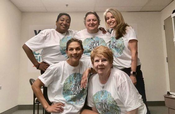 five ladies from the Right at Home South Shore Long Island Office posing with matching "because someone I love is a Senior" t-shirts