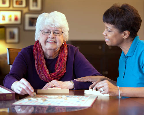 Female Caregiver Giving Memory Care With A Senior Female