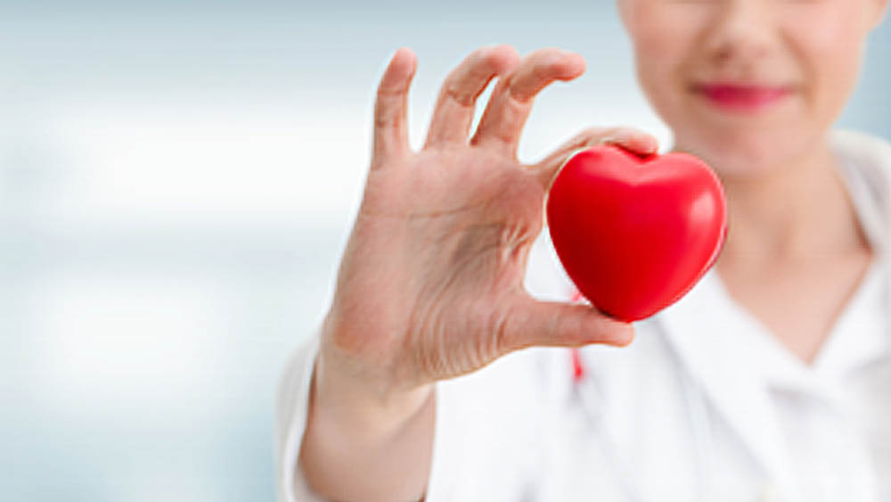 Woman Holding Up A Heart Representing Heart Health Month