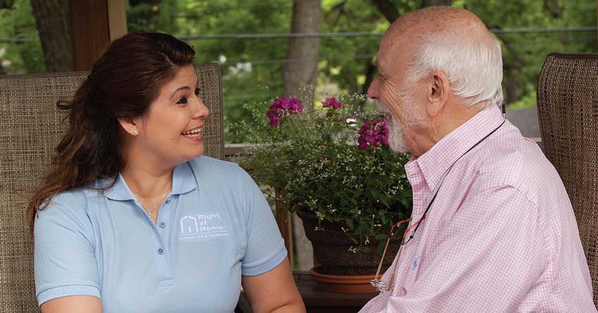 An Oak Creek, Wisconsin female caregiver having a conversation with a male client on an outdoor patio.