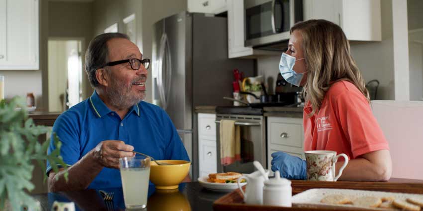 Caregiver and client at breakfast table