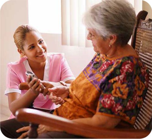 caregiver helping senior use remote control