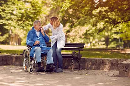 senior sitting outside with caregiver