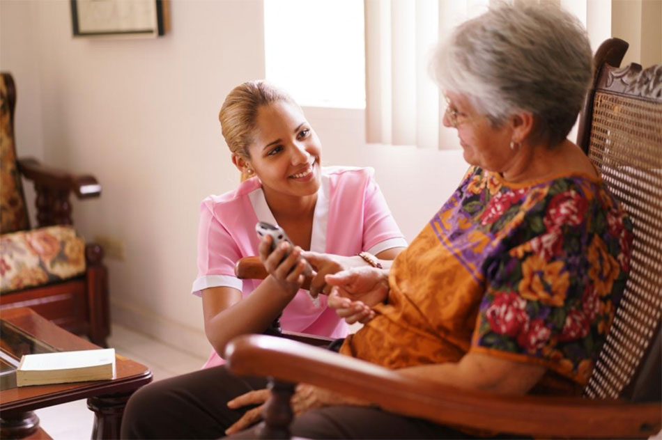 caregiver helping senior sitting in chair