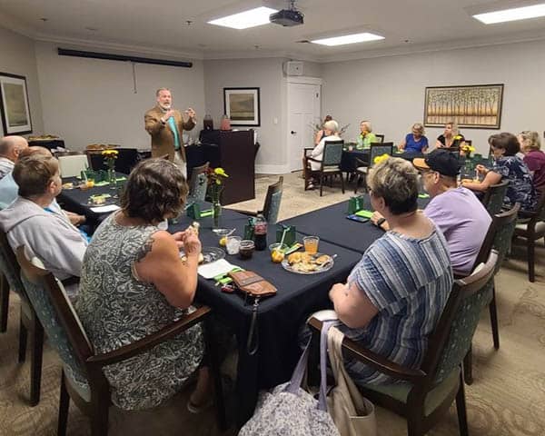 A conference room of people listening to Charlie.