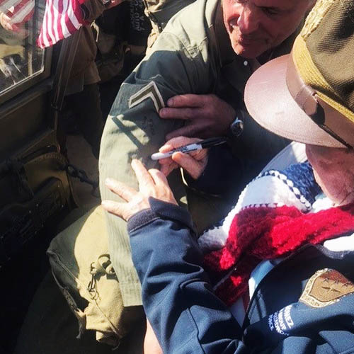 Senior Veterans in a Wheelchair Autographing a Military Jacket