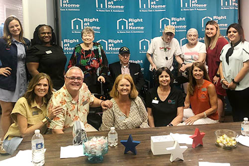 Group photo of all of the men and women attendees and staff seated and standing at a Holocaust Survivors and Veterans Gathering