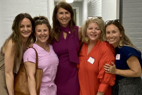 Five Women Pose for a Photo in Front of a Blue Door at an Open House in Lafayette