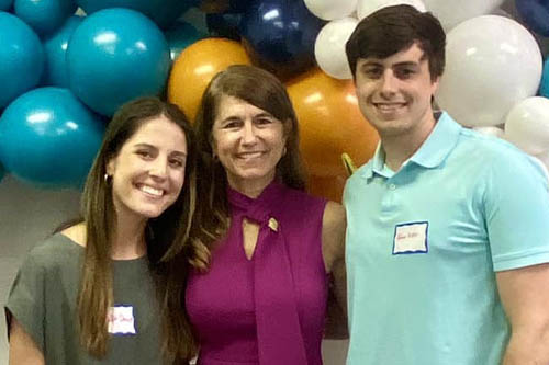 Two Women and a Man Pose for a Photo in Front of Balloons at an Open House in Lafayette