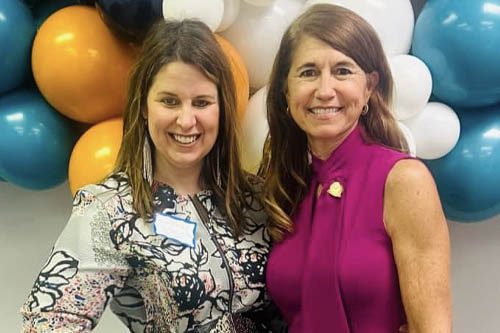 Two Women Pose for a Photo in Front of Balloons at an Open House Event in Lafayette