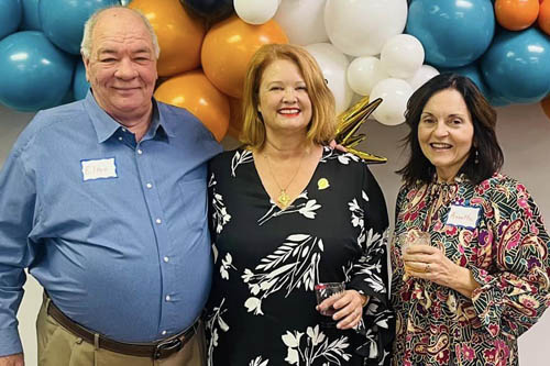 A Man and Two Women Pose for a Photo in Front of Balloons at an Open House in Lafayette