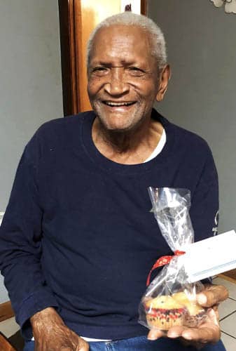 African American Senior Veteran Holding Package of Gift Muffins