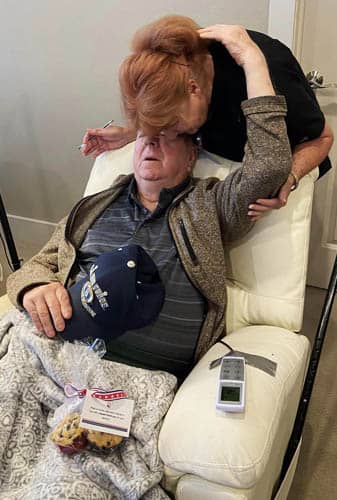 Senior Veteran Man In Recliner Hugging His Caregiver