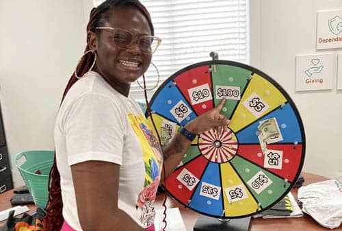 African American Caregiver Spinning a Prize Wheel During Right at Home Rockwall's Caregivers Week Festivities
