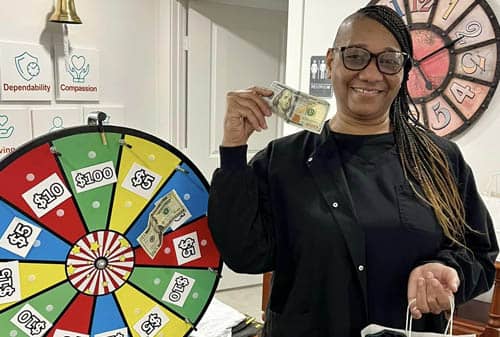 African American Caregiver Spinning a Prize Wheel at Right at Home Rockwall's Caregivers Week Festivities