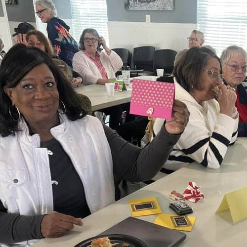 Senior Woman Holding Up A Greeting Card She Wrote During a Send a Card Event