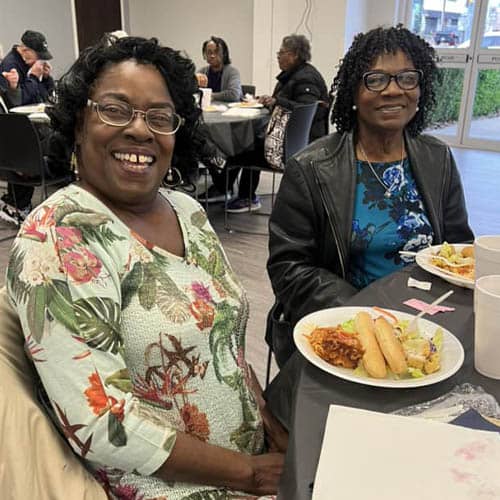 Two African American Women Enjoying a Meal During the Trinity Hospice Luncheon