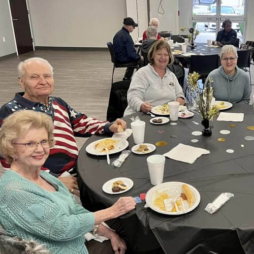 Table of Residents Enjoying a Meal During the Trinity Hospice Luncheon