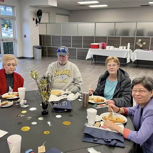 Table of Senior Residents Enjoying a Meal During the Trinity Hospice Luncheon