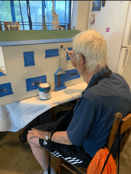 senior client painting dollhouse