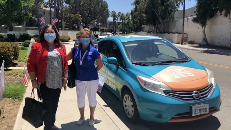 Carmen on left and Melanie on the right next to Right at Home wrapped vehicle