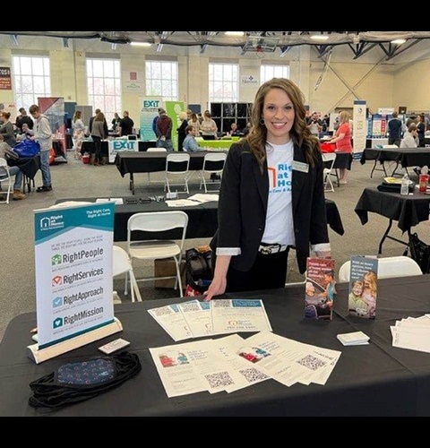 chrisy-in-back-of-table-at-marietta-college-job-fair-compressed