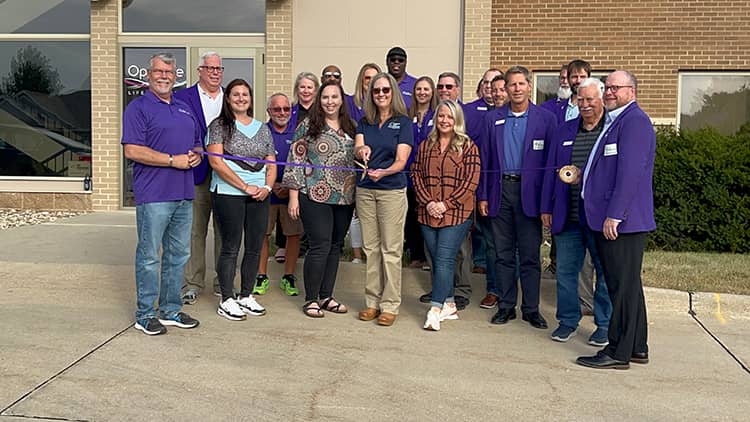 owner stephanie myers and employees of right at home cedar falls in front of the location for the grand opening ribbon cutting