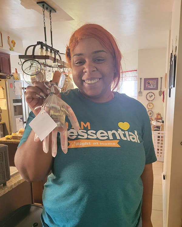 A female caregiver holds up a glove filled with candy.