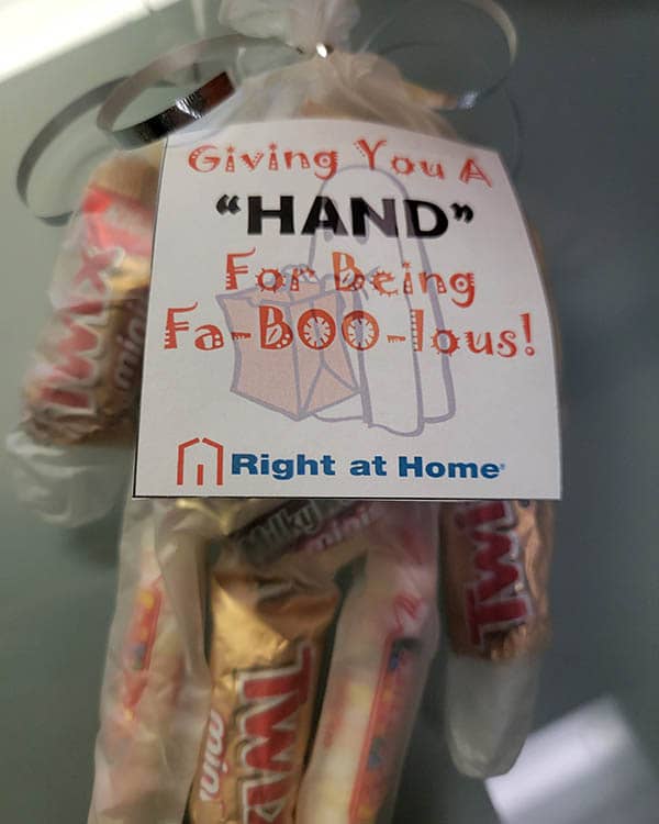 A plastic glove filled with candy. A sign is attached that says Giving you a "hand" for being Fa-BOO-lous!