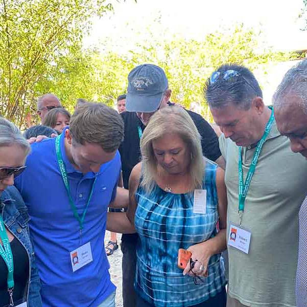 A group of Right at Home Franchise Owners praying together at the event where they were helping Josiah's House